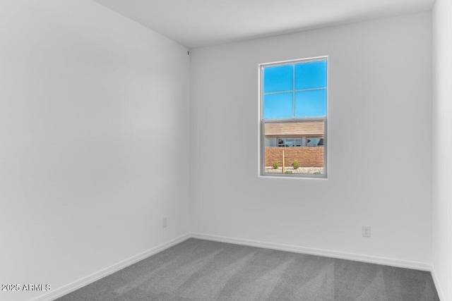 carpeted empty room with baseboards