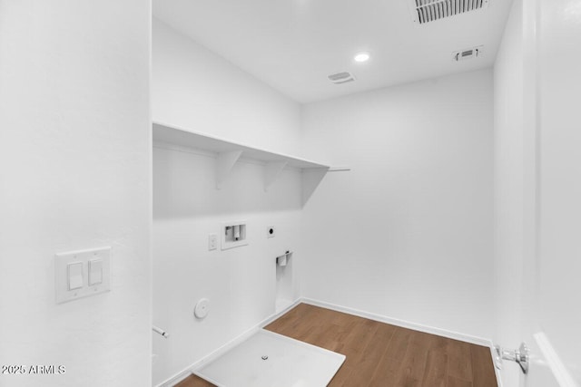 clothes washing area featuring washer hookup, hookup for a gas dryer, visible vents, wood finished floors, and laundry area