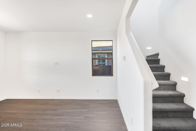 stairway with recessed lighting, wood finished floors, and baseboards