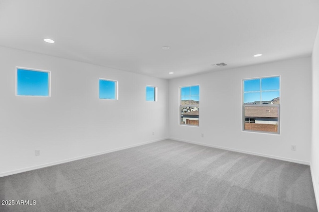 empty room with carpet, visible vents, baseboards, and recessed lighting