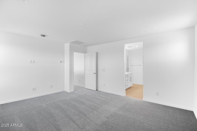 unfurnished bedroom with baseboards, connected bathroom, visible vents, and light colored carpet