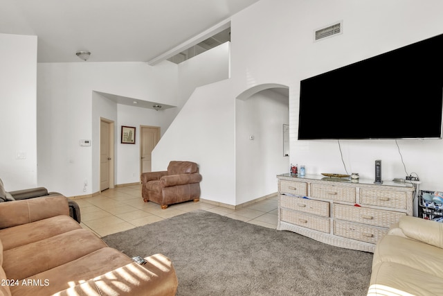 living room with light tile patterned flooring and high vaulted ceiling