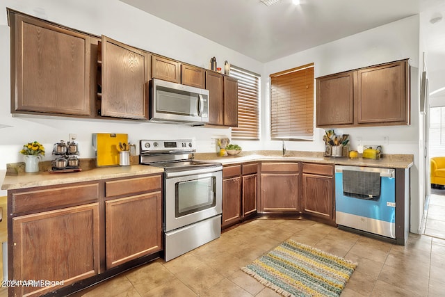 kitchen with light tile patterned flooring and appliances with stainless steel finishes