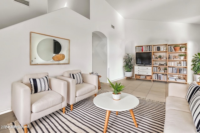 living room featuring high vaulted ceiling and tile patterned floors