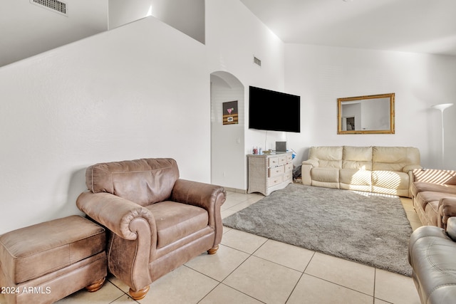 living room with light tile patterned floors and high vaulted ceiling