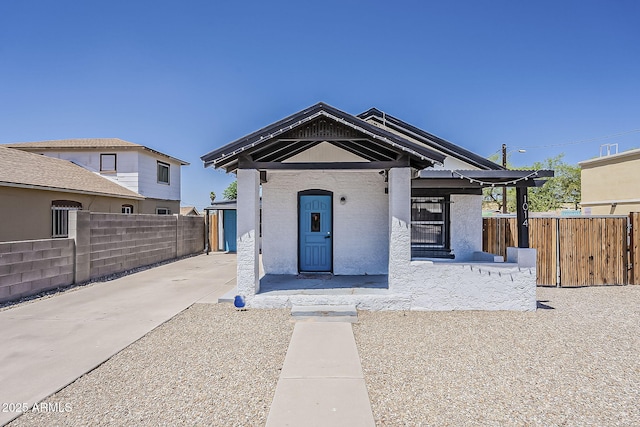 view of front of house with fence, stucco siding, and driveway