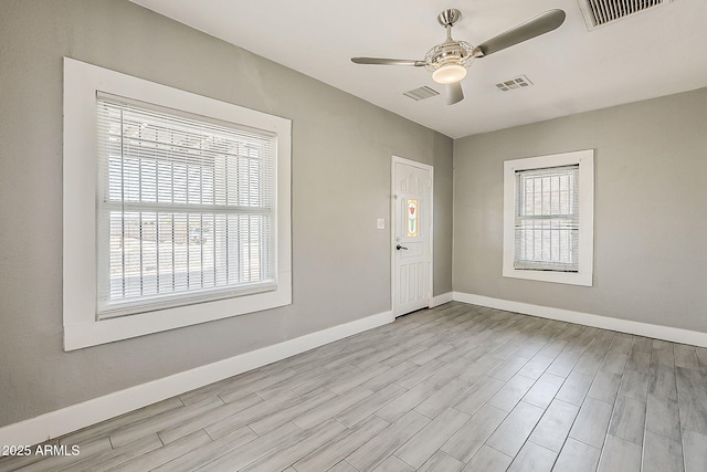 empty room featuring a ceiling fan, baseboards, and wood finished floors