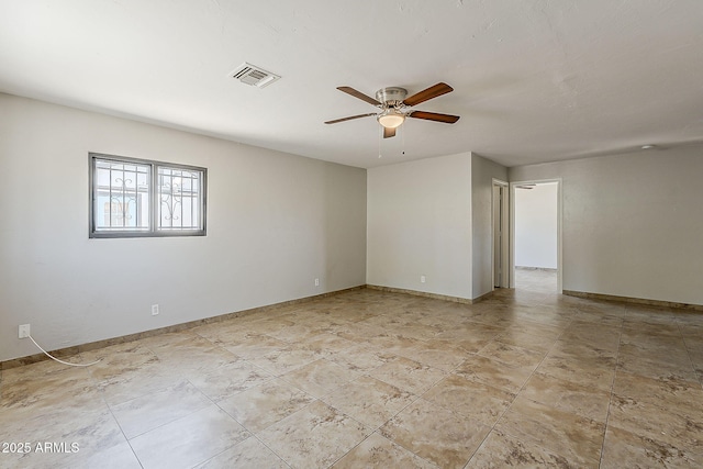 unfurnished room featuring a ceiling fan and baseboards