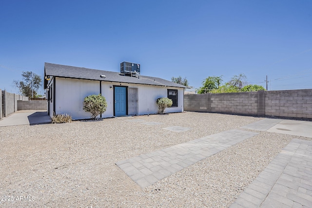 rear view of house featuring central AC unit, a fenced backyard, and a patio area