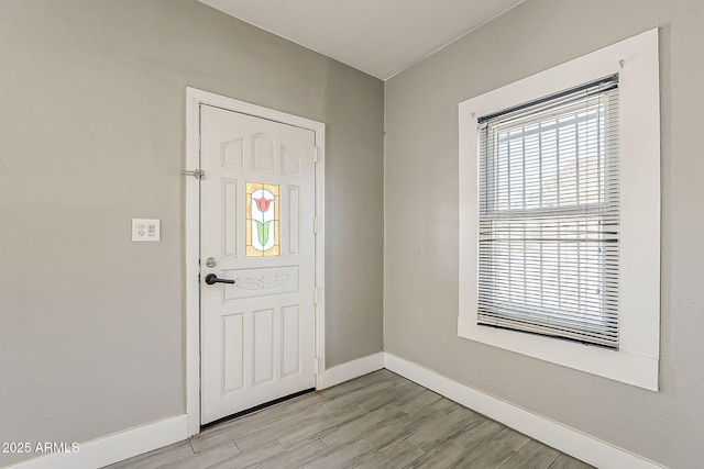 foyer featuring baseboards and light wood finished floors