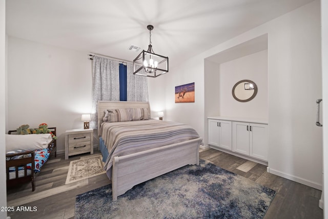 bedroom with dark hardwood / wood-style flooring and a chandelier