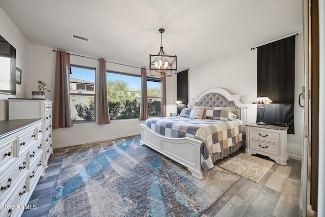 bedroom with a chandelier and hardwood / wood-style flooring