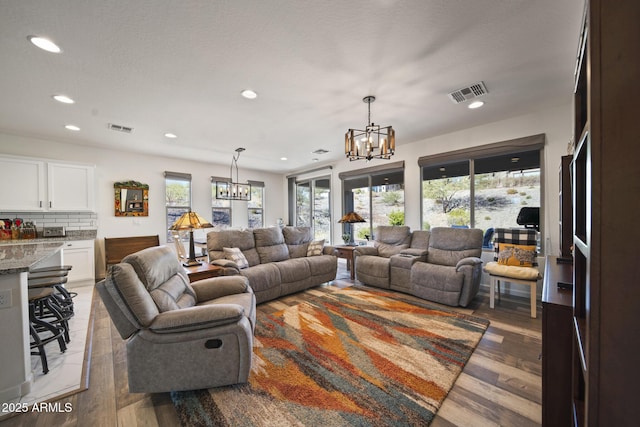 living room featuring light hardwood / wood-style floors, a notable chandelier, and a healthy amount of sunlight