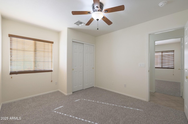 unfurnished bedroom featuring carpet floors, a closet, and ceiling fan