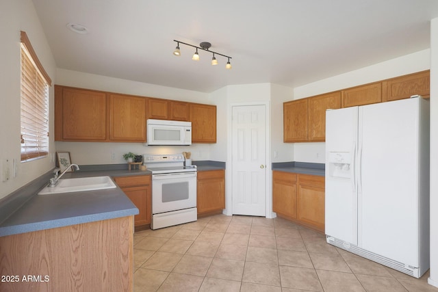 kitchen featuring white appliances, sink, and light tile patterned floors