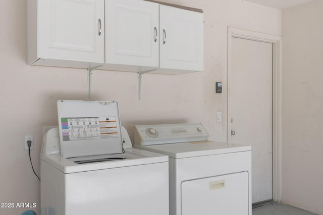 laundry area with cabinets and washing machine and clothes dryer