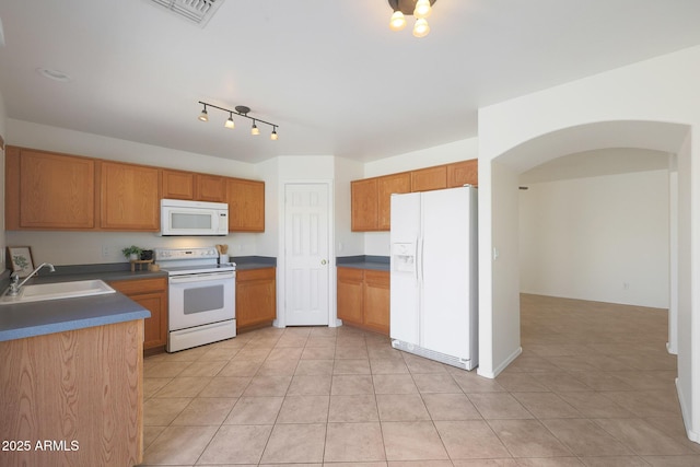 kitchen featuring sink, light tile patterned floors, and white appliances