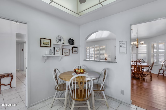 dining room featuring light wood-type flooring and an inviting chandelier