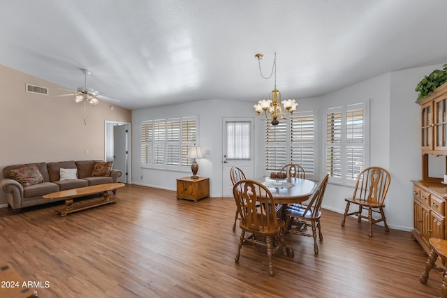 dining area featuring ceiling fan with notable chandelier, a healthy amount of sunlight, lofted ceiling, and hardwood / wood-style flooring