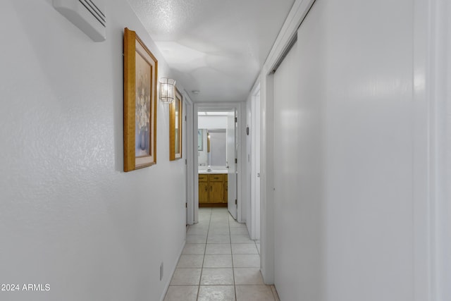 hallway with an AC wall unit and light tile patterned flooring