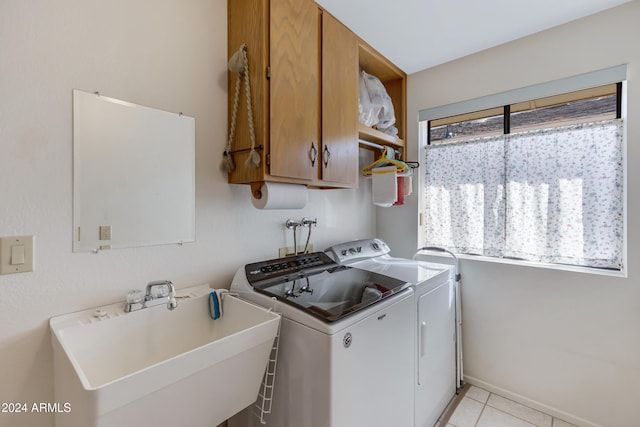 washroom with a wealth of natural light, sink, light tile patterned floors, and cabinets