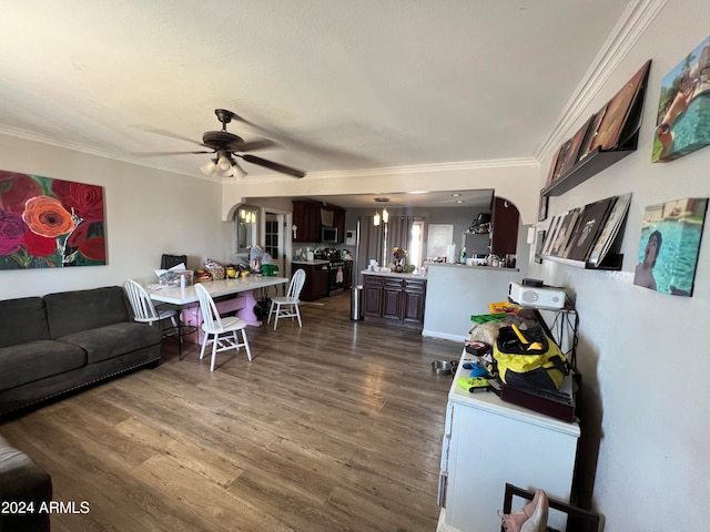 living room featuring crown molding, dark wood-type flooring, and ceiling fan