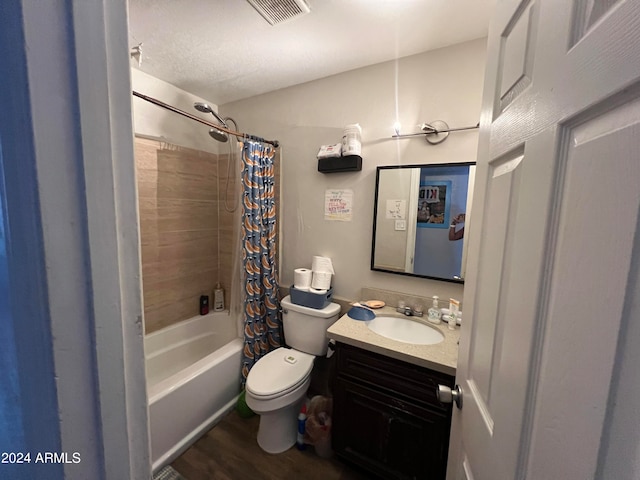 full bathroom featuring wood-type flooring, a textured ceiling, shower / tub combo with curtain, vanity, and toilet