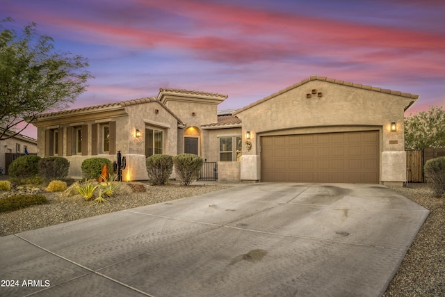 15201 S 183rd Dr, Goodyear, AZ 85338 - mediterranean / spanish home featuring driveway, a gate, stucco siding, fence, and a garage