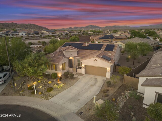 pool at dusk with a patio, an in ground hot tub, and pool water feature