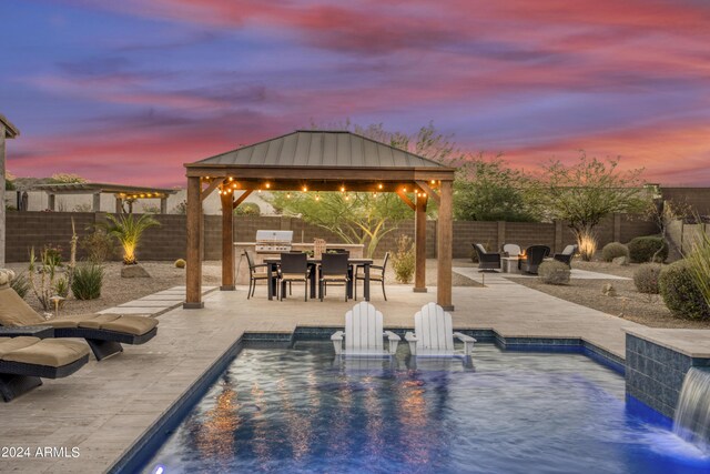 pool at dusk featuring pool water feature, a patio, and a gazebo