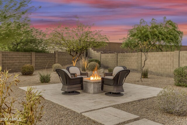 patio terrace at dusk featuring an outdoor fire pit