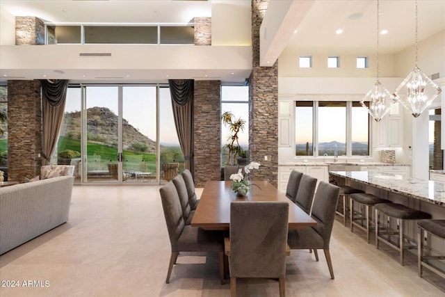 dining room with a mountain view, a towering ceiling, and an inviting chandelier