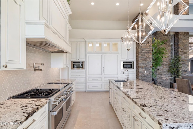 kitchen with pendant lighting, sink, decorative backsplash, appliances with stainless steel finishes, and white cabinetry