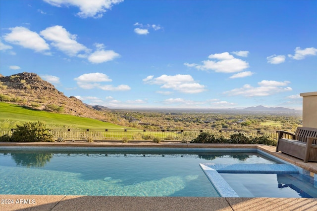 view of swimming pool with a mountain view and an in ground hot tub