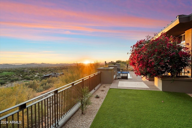 yard at dusk with a mountain view and a patio area