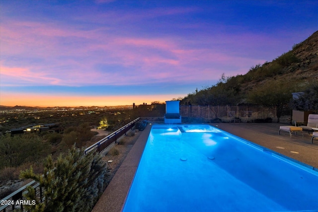 pool at dusk with a patio