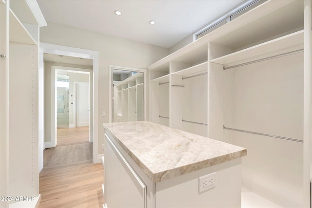 walk in closet with light wood-type flooring