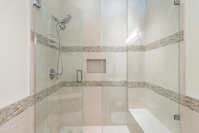 bathroom with a shower with shower door and tile walls