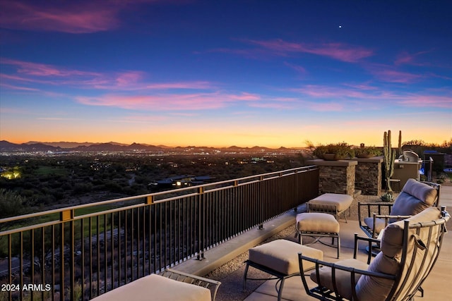 balcony at dusk featuring a mountain view