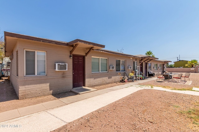 exterior space with a patio and a wall mounted AC