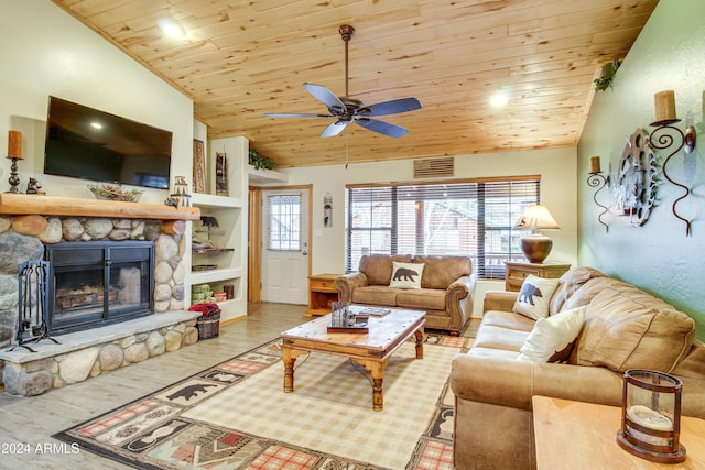 living area featuring wood ceiling, a healthy amount of sunlight, a stone fireplace, and wood finished floors