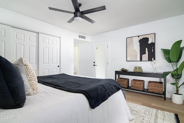 bedroom with a closet, ceiling fan, and light wood-type flooring