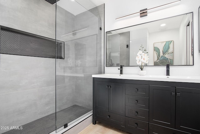 bathroom featuring vanity, hardwood / wood-style flooring, and tiled shower