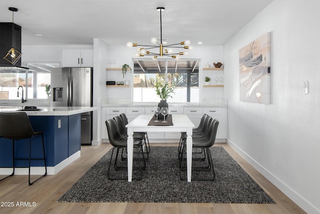 dining space featuring plenty of natural light, sink, a chandelier, and light hardwood / wood-style floors