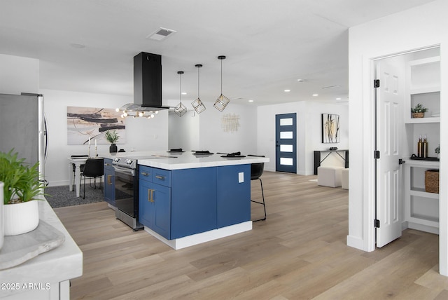 kitchen featuring appliances with stainless steel finishes, a kitchen island, decorative light fixtures, blue cabinets, and island exhaust hood