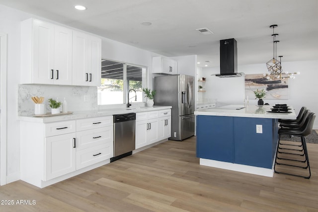 kitchen featuring decorative light fixtures, light wood-type flooring, island exhaust hood, stainless steel appliances, and white cabinets