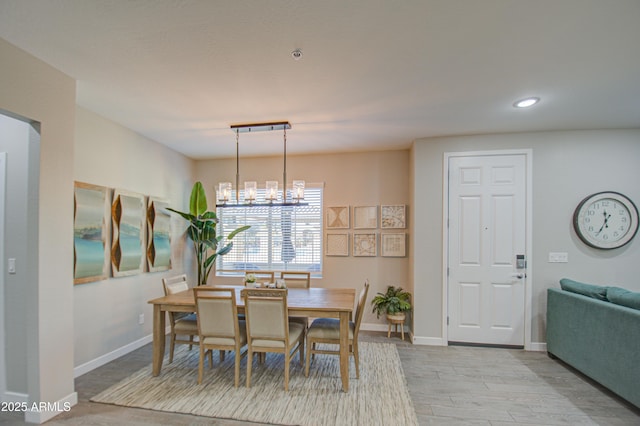 dining space with light wood-type flooring and a chandelier