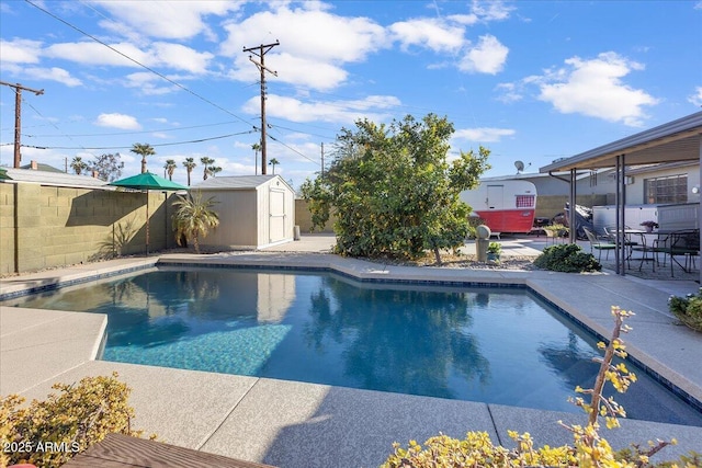 view of swimming pool featuring a storage unit and a patio