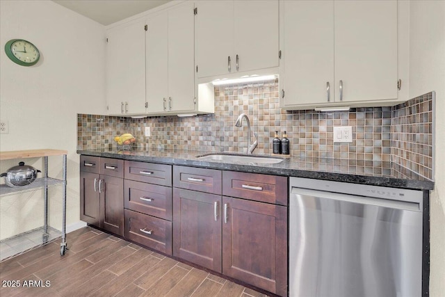 kitchen with stainless steel dishwasher, white cabinets, backsplash, and sink