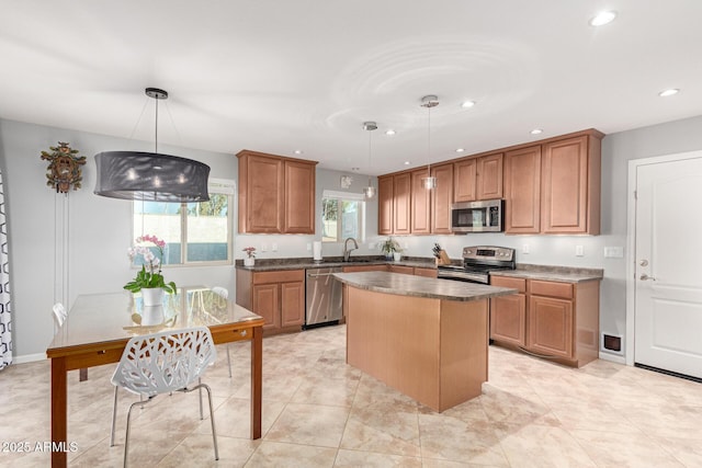 kitchen with sink, decorative light fixtures, stainless steel appliances, and a center island